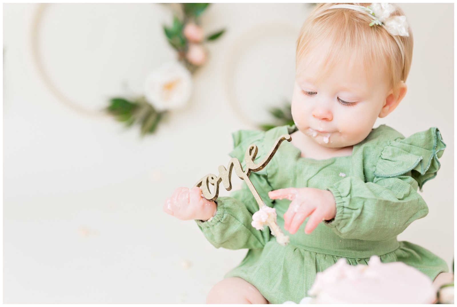1 year old eating pink naked cake, organic floral hoops in background, cake smash session