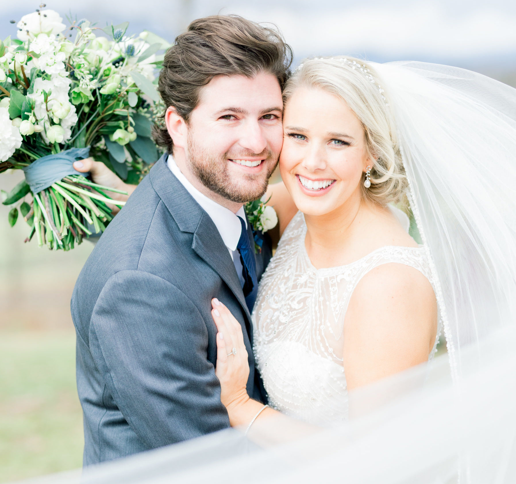 Bride and groom looking at the camera with flowing veil