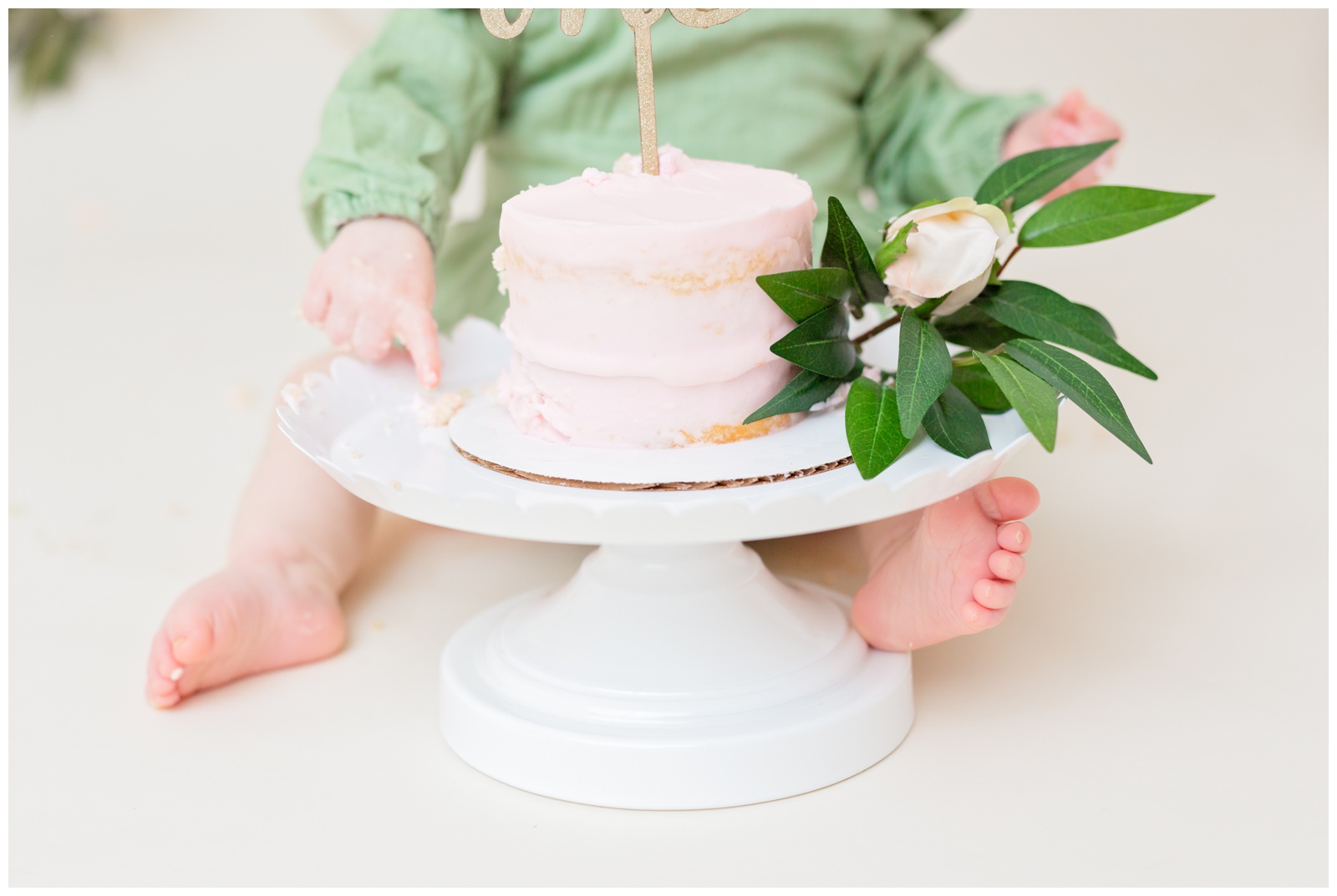 pink naked cake, baby toes, organic floral hoops in background, cake smash session
