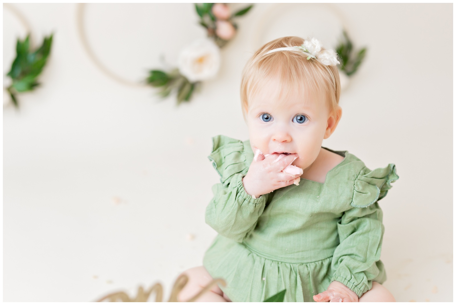 1 year old eating pink naked cake, organic floral hoops in background, cake smash session